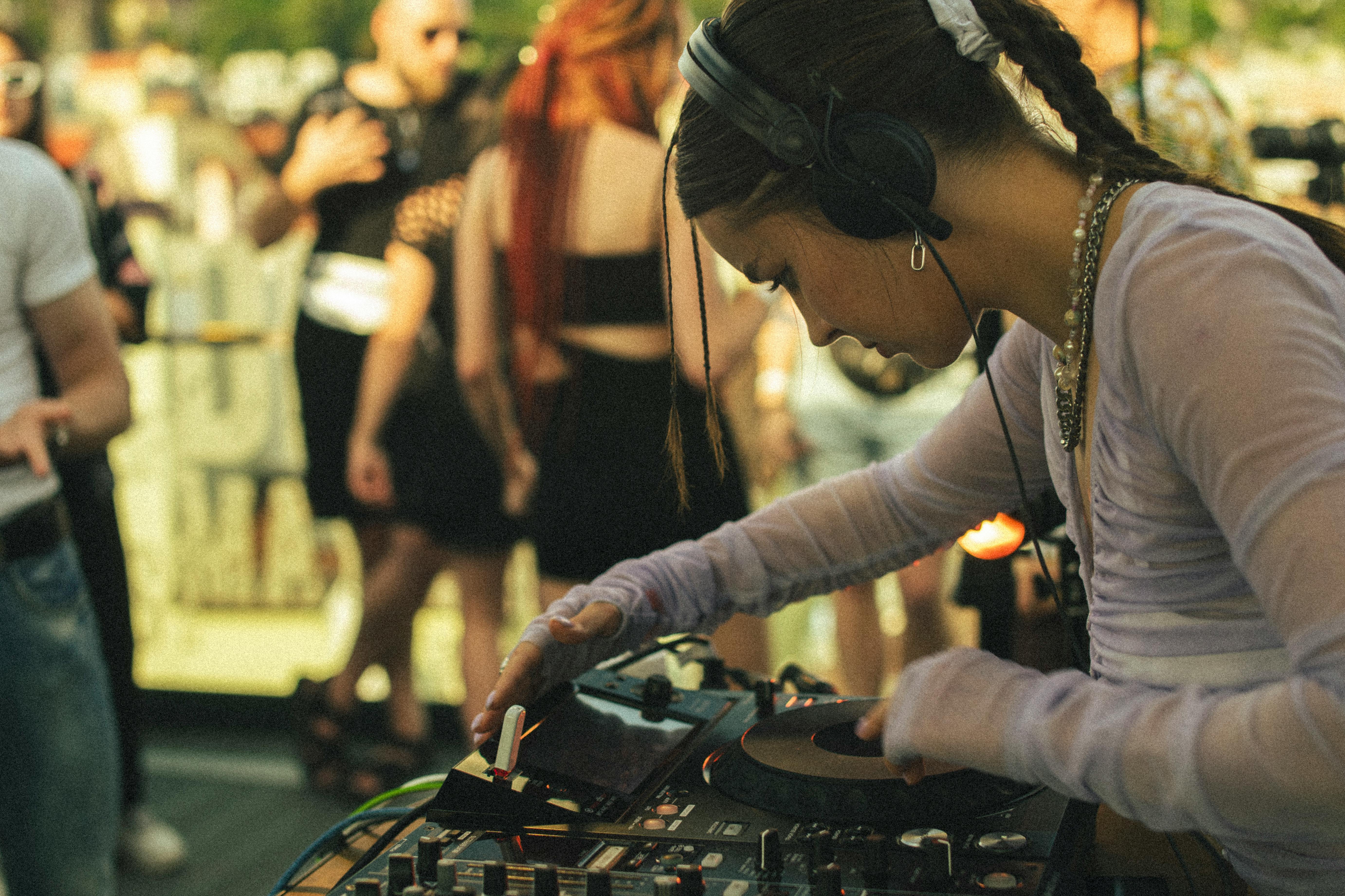 Jeune femme DJ concentrée lors de ses premiers événements, en train de mixer