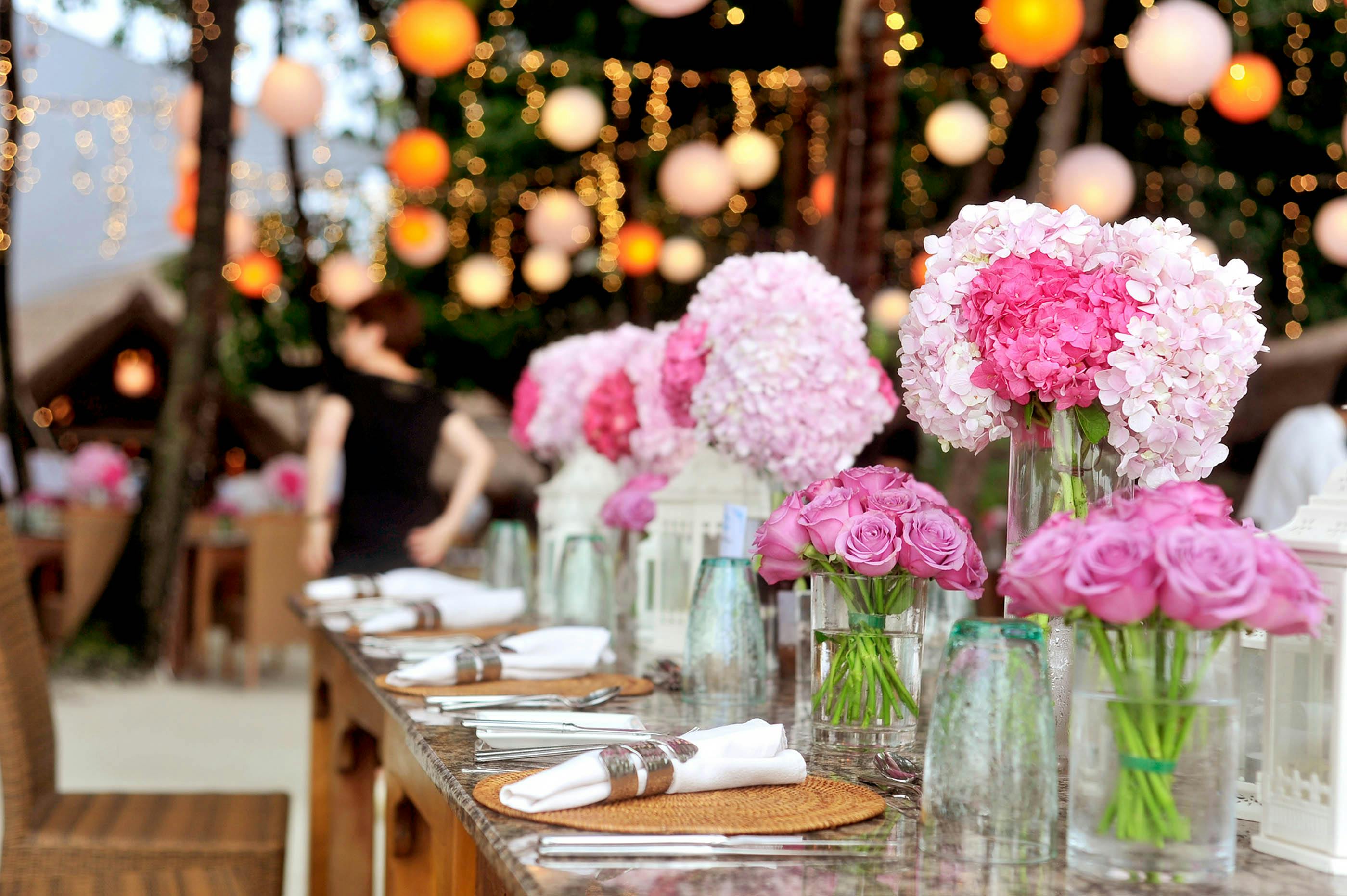 Table élégamment dressée pour une occasion festive, probablement un mariage, avec vaisselle, décorations et ambiance soignée
