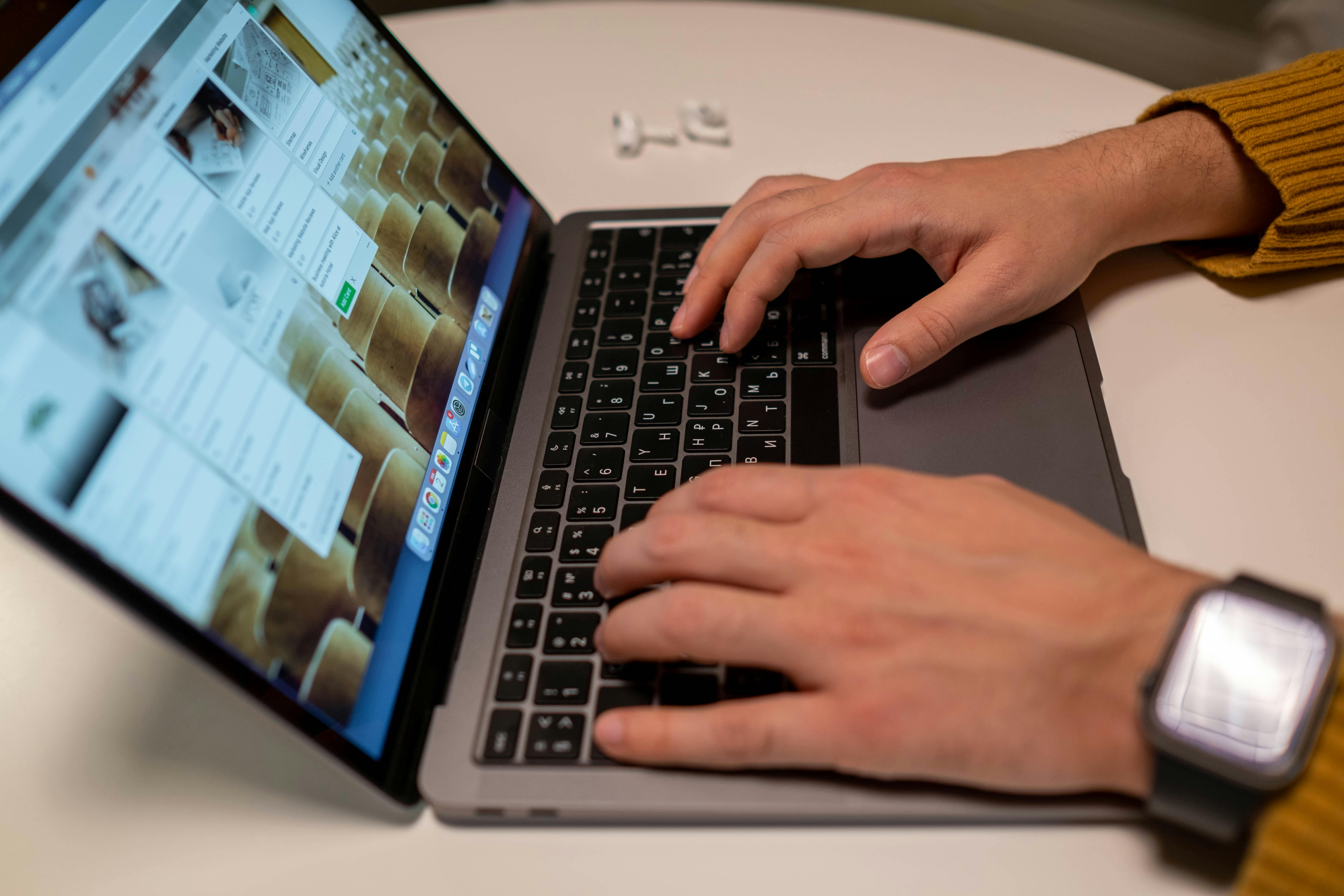 Mains tapant sur un clavier d’ordinateur affichant un planning de tâches à réaliser