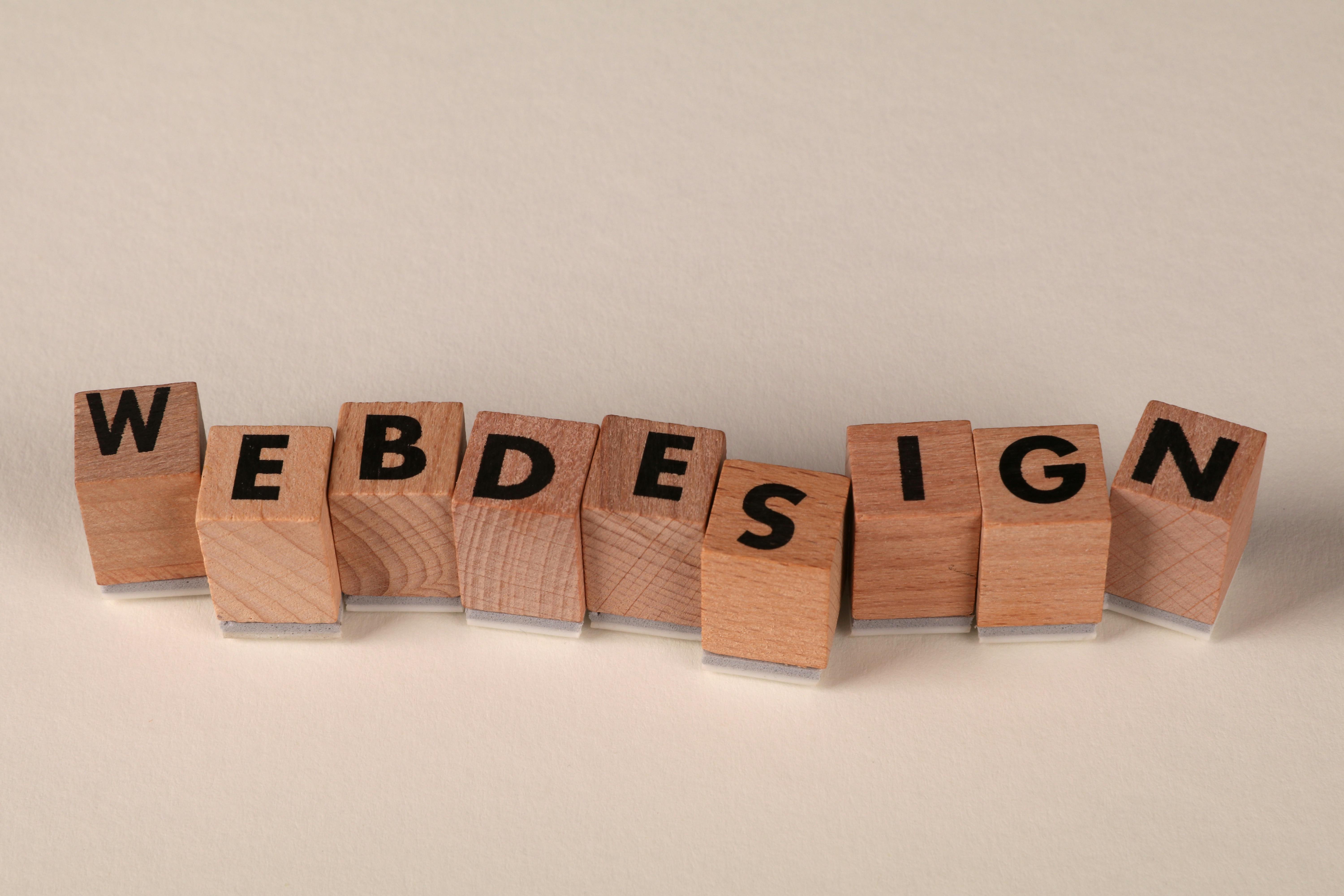 Des blocs en bois formant les mots "web design" sur un fond neutre