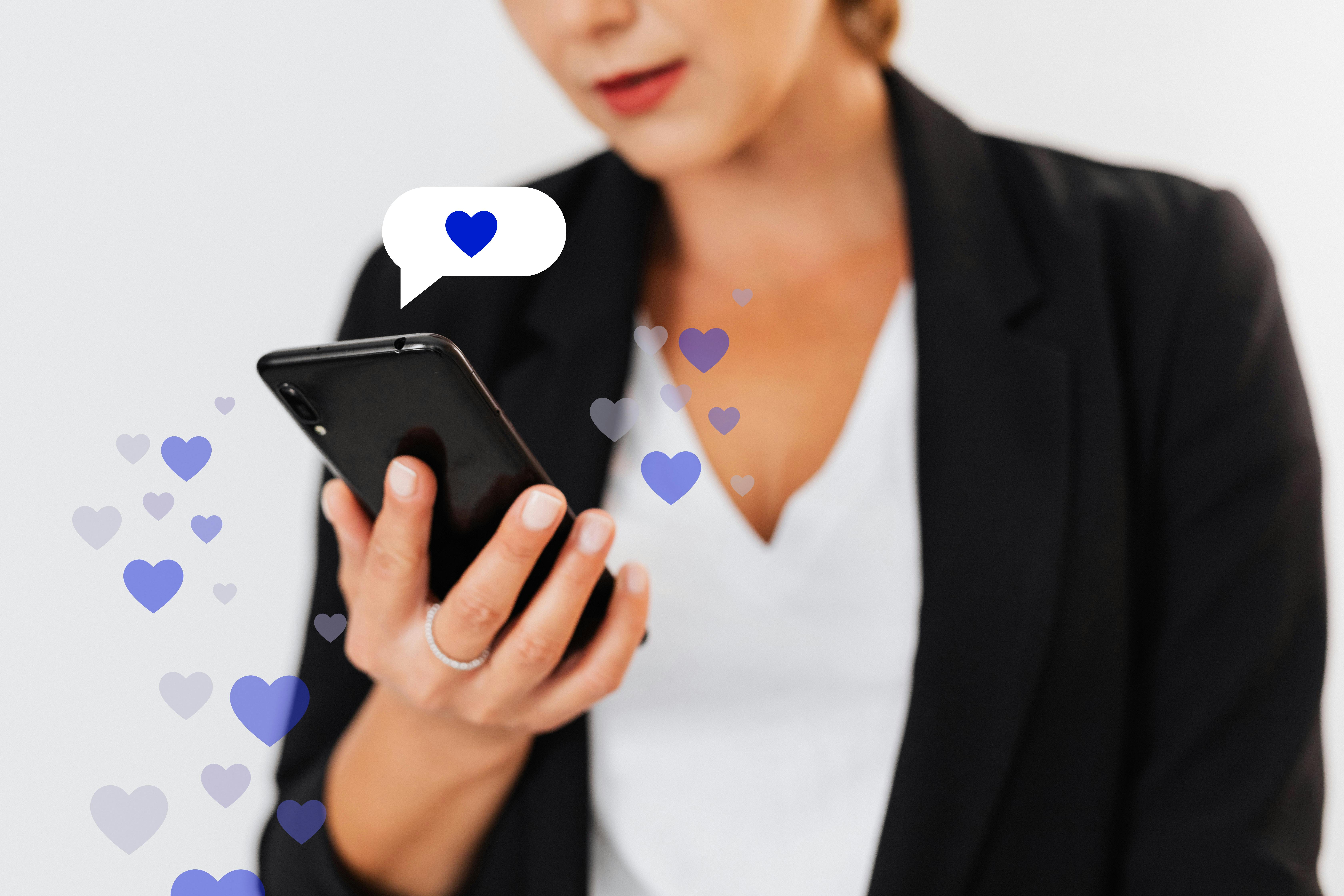 Jeune femme professionnelle regardant son smartphone, entourée de cœurs bleus en animation illustrant l’engagement ou l’interaction sur les réseaux sociaux