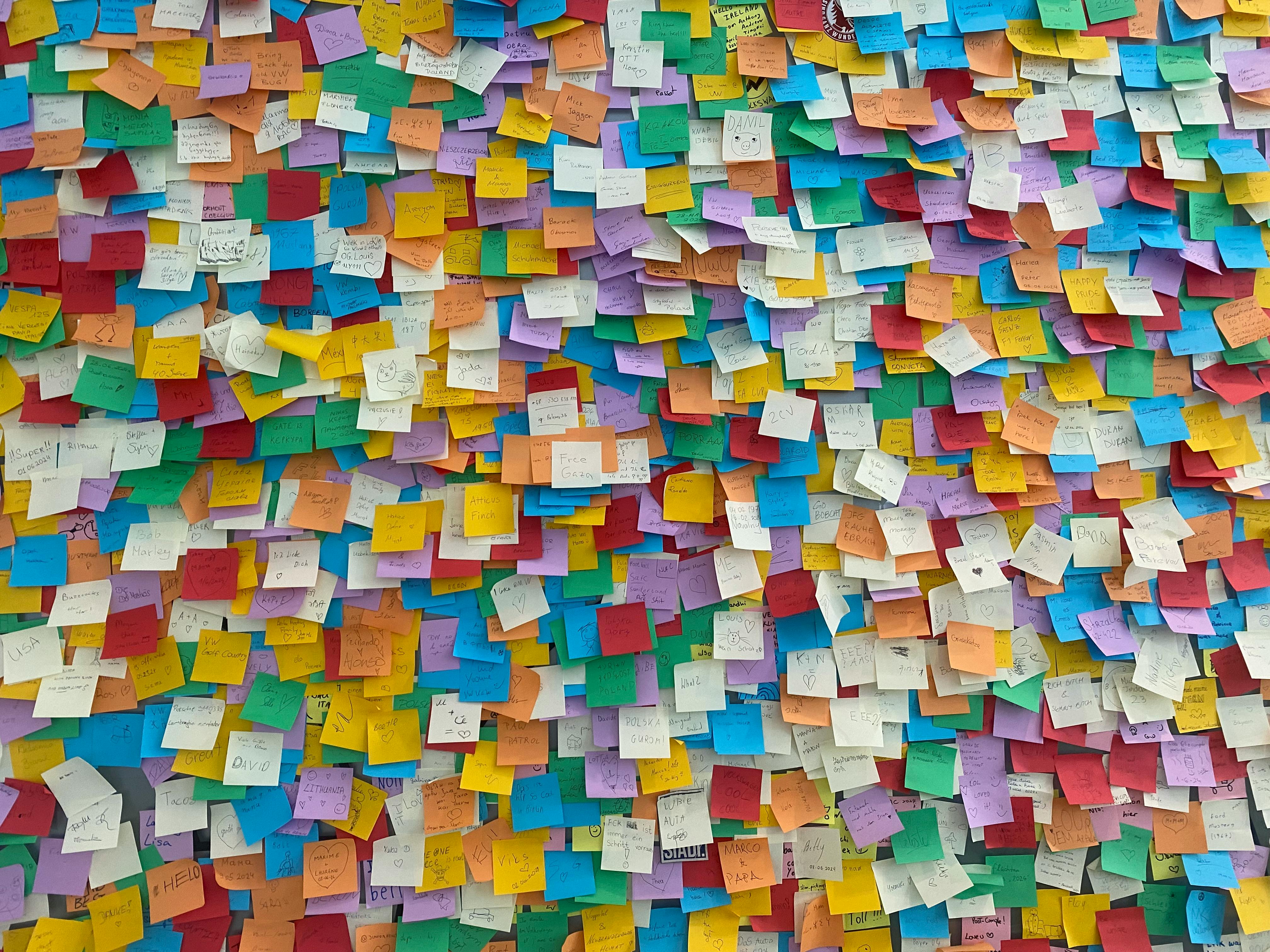 Un mur recouvert de nombreux post-it colorés, organisés de manière aléatoire