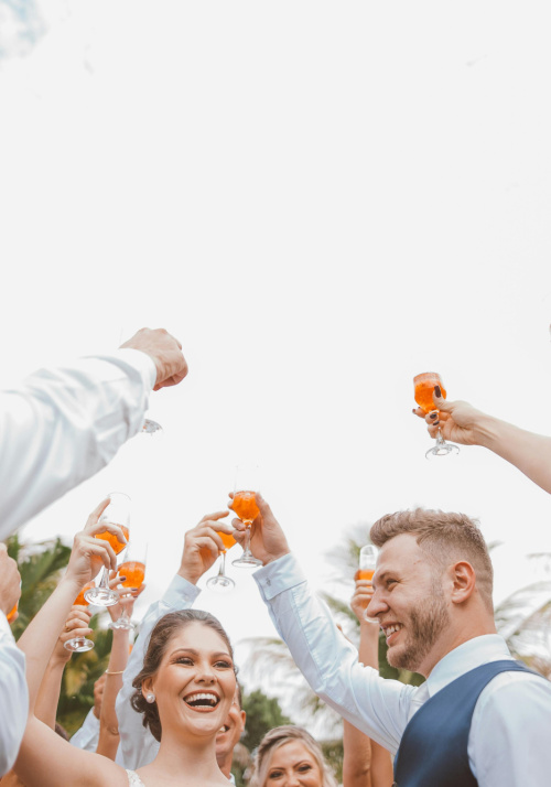 Groupe de personnes levant chacun un verre de vin et célébrant les mariés au centre